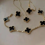 Elegant black clover jewelry set featuring a gold-outlined four-leaf clover design with necklace, bracelet, ring, and earrings – anti-tarnish luxury jewelry by Vellura Jewellery