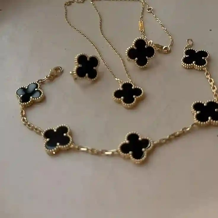 Elegant black clover jewelry set featuring a gold-outlined four-leaf clover design with necklace, bracelet, ring, and earrings – anti-tarnish luxury jewelry by Vellura Jewellery