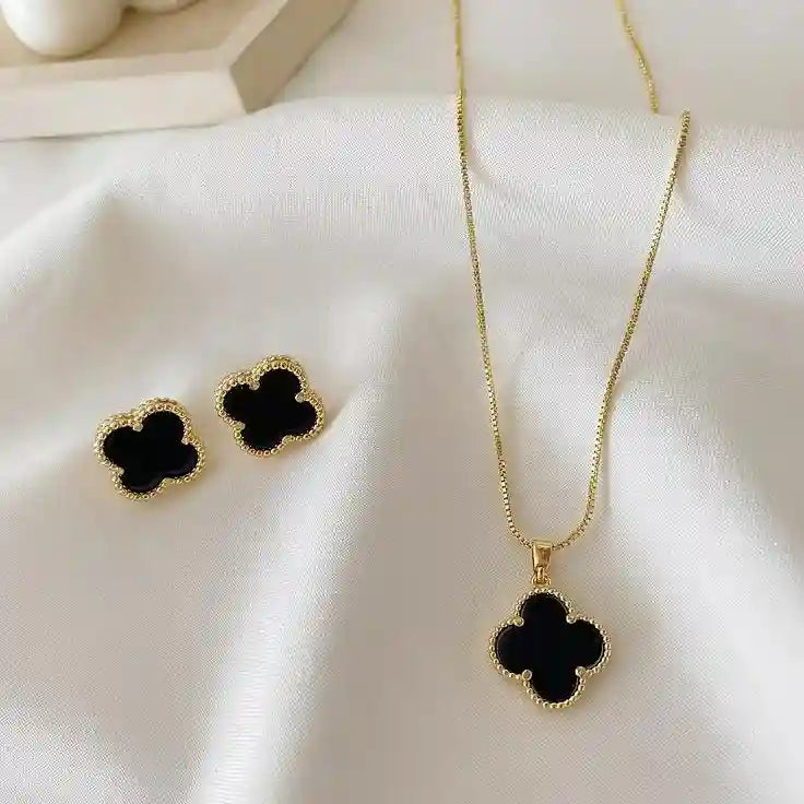 Elegant black clover jewelry set featuring a gold-outlined four-leaf clover design with necklace, bracelet, ring, and earrings – anti-tarnish luxury jewelry by Vellura Jewellery