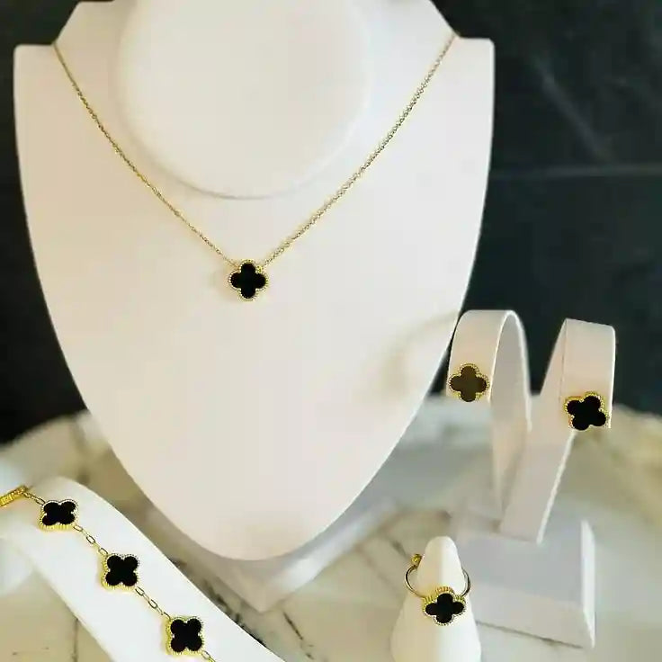 Elegant black clover jewelry set featuring a gold-outlined four-leaf clover design with necklace, bracelet, ring, and earrings – anti-tarnish luxury jewelry by Vellura Jewellery